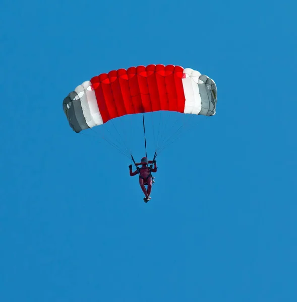 Skydiver con un paracadute colorato molto luminoso su un bac cielo blu — Foto Stock