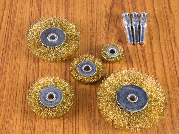 Round steel wire brush of various sizes on a wooden table.