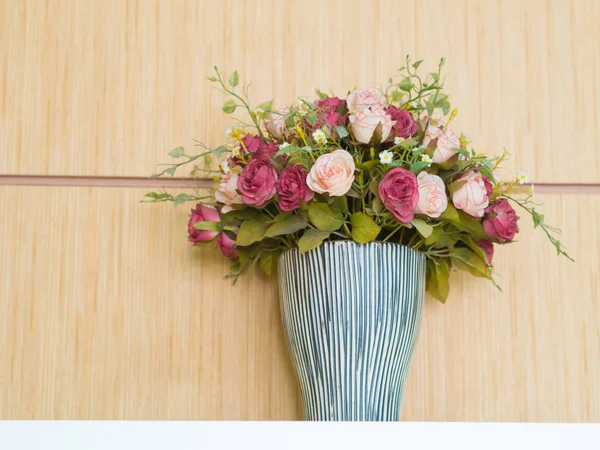 Flores artificiais em vaso. nas prateleiras são feitas de madeira . — Fotografia de Stock