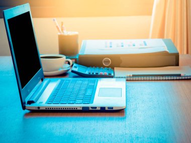 Dizüstü bilgisayarlar ile boş perde, hesap makinesi ve belge üzerinde yerleştirilmiş ahşap Resepsiyon sabah dosya. yan görünüm.