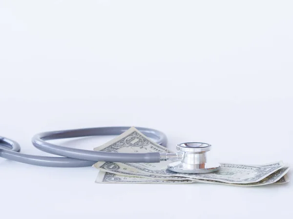聴診器と白い背景の上のお金。健康ケアのためのお金の概念. — ストック写真
