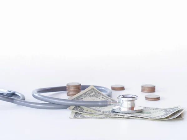 聴診器と白い背景の上のお金。健康ケアのためのお金の概念. — ストック写真