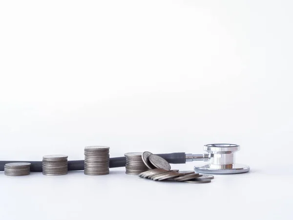 白い背景の上の聴診器とコイン スタック。健康管理、財政援助の概念のためのお金. — ストック写真