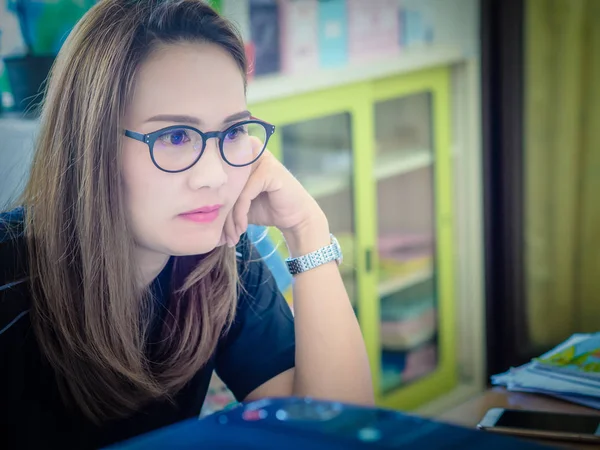 Gyönyörű ázsiai nők irodájában dolgozik. Látszó-on egy számítógép képernyőjén. szemüveges. — Stock Fotó