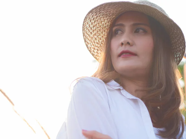 Ázsiai legszebb nő a réten, fehér inget visel, és barna kalapban. Egy napsütéses napon. — Stock Fotó