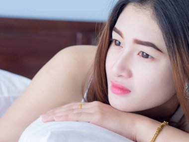 Onun yatağında beyaz yelek Asyalı kadın portresi fikri kırık kalp ve üzüntü ifade ediyorum. umutsuz ve bekliyor, kavram.