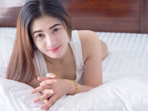 Fehér mellény, ágyon, ázsiai nő portréja várják koncepció. — Stock Fotó