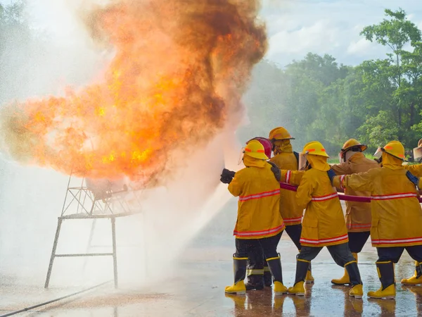 Brandmän utbildning. Spraya vatten brandskyddsutrustning drift. — Stockfoto