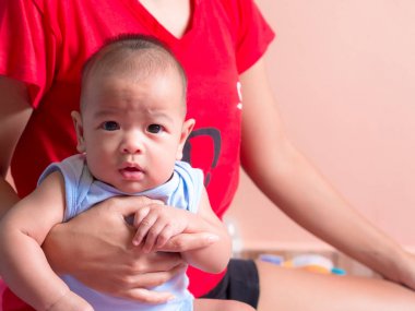 yakın, Asya bebek annesinin kollarında.