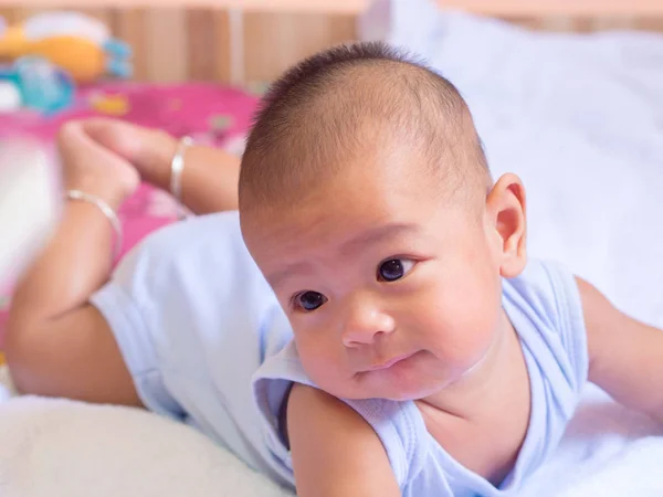 Asiático bebé mentira en el estómago, en blanco colchón . — Foto de Stock