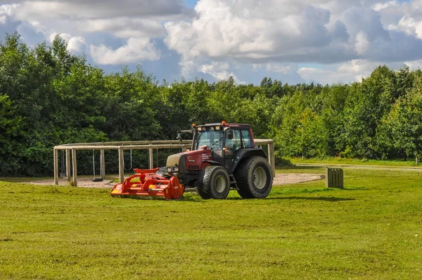 Traktor mäht Gras in einem Park — Stockfoto