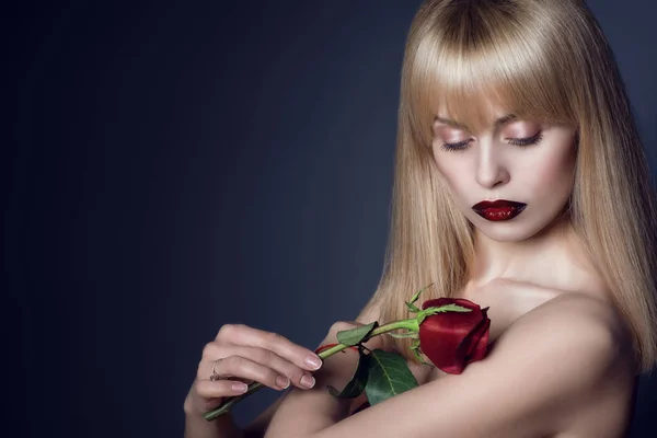 Portrét nádherné blond model s nude make-up na oči a rty víno červené ombre dotýkání kůži paže s růže bud, nahá ramena. Zblízka. Kopírování prostor — Stock fotografie