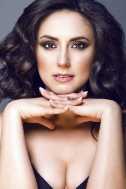 Orta yaşlı güzel esmer ile mükemmel makyaj ve çıplak omuz onun parmak çarpı işareti altında çene kameraya, düz seyir portresi kapatın