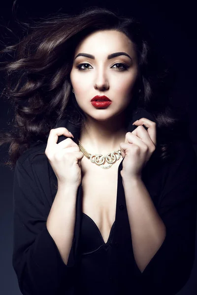 Portret van glam dark-haired model met perfecte make-up en vliegen golvende zijdeachtig haar gouden luxe ketting dragen. Geïsoleerd op zwarte achtergrond — Stockfoto