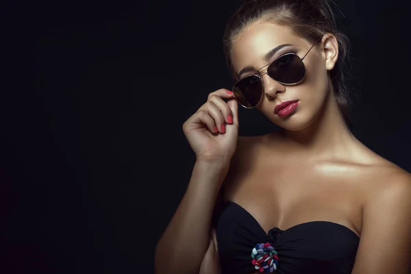 Close up portrait of young gorgeous tanned model with casual updo hair and beautiful make up wearing trendy aviator sunglasses — Stock Photo, Image