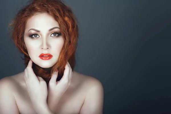 Portret przepiękny czerwony zatytułowany kobiety z piękny makijaż i nagie ramiona nawijania jej włosy wokół szyi z bliska — Zdjęcie stockowe