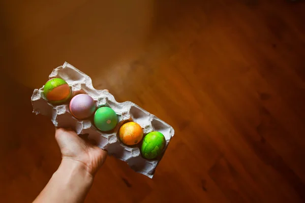 Womans hand holding a paper tray with easter eggs — Stock Photo, Image