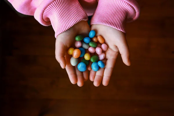 Bunch of candies in childs hands — Stock Photo, Image