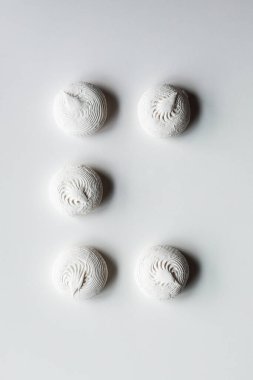 Beyaz arkaplanda beş beyaz zephyr şekeri ve kayıp bir nesne.