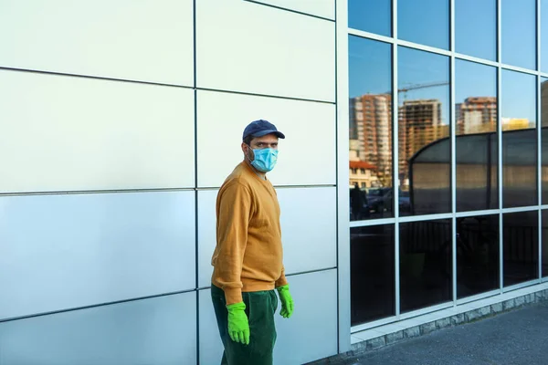 Muž v lékařské masce a rukavice v blízkosti nákupního centra — Stock fotografie