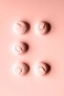 Pembe arka planda beş pembe zephyr şekerlemesi ve bir kayıp eşya.