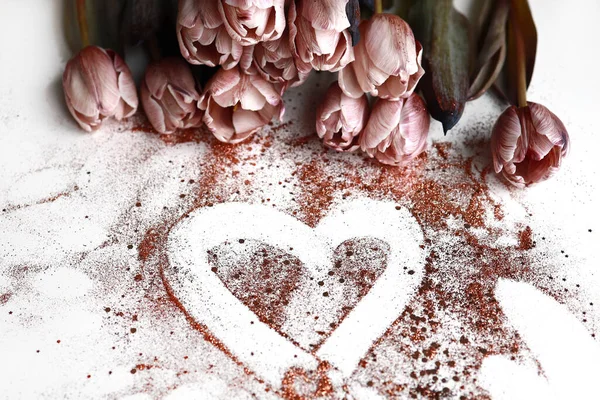 Кучка пыльных розовых тюльпанов с бронзовым блестящим сердцем — стоковое фото