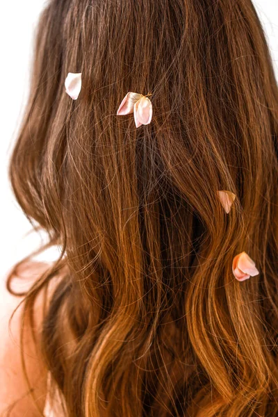 Pétalas em mulheres cabelo fechar — Fotografia de Stock