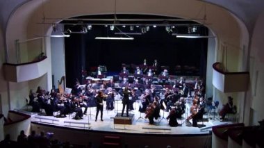 DNIPRO, UKRAINE - 15 Şubat 2018: Ünlü kemancı Dmitry Tkachenko ve Akademik Senfoni Orkestrası - ana orkestra şefi Natalia Ponomarchuk Filarmoni 'de Antonin Dvorak tarafından seslendirilen müzik.
