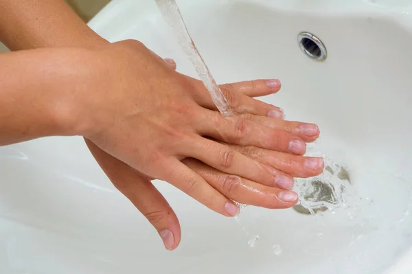女人在流水下洗手 白色水槽喷出铬 — 图库照片