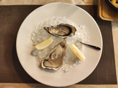 Limonlu taze istiridye ve buzlu büyük bir tabak..