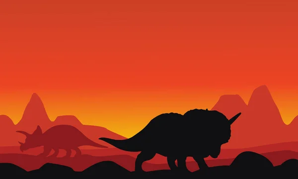 Silhouet van dinosaurus triceratops met achtergronden van de berg — Stockvector