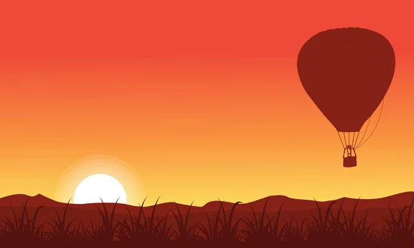 Silhueta de balão de ar quente no céu laranja — Vetor de Stock