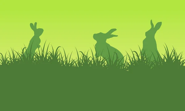 Силуэт кролика на зеленом фоне — стоковый вектор