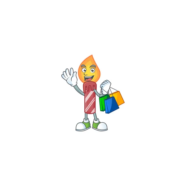 Cheerful red stripes candle cartoon character waving and holding Shopping bags — Stock Vector