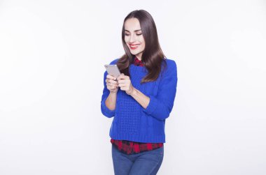 Güzel genç kadın telefonda bir ileti yazar.