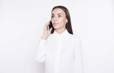 Telefon ve beyaz bir arka plan üzerinde gülümseyen iş kadını konuşuyor.