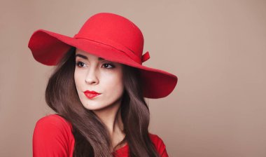 Kadın güven. Çok güzel esmer kız kırmızı parlak ruj ve büyüleyici bir içinde başında zarif kırmızı şapka kırmızı elbise portresi.