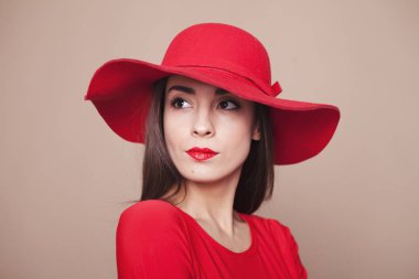 Nazik bir bakışta. Çok güzel esmer kırmızı ruj ve büyüleyici bir içinde başında şık şapka kırmızı elbise mesafe içine görünüyor.