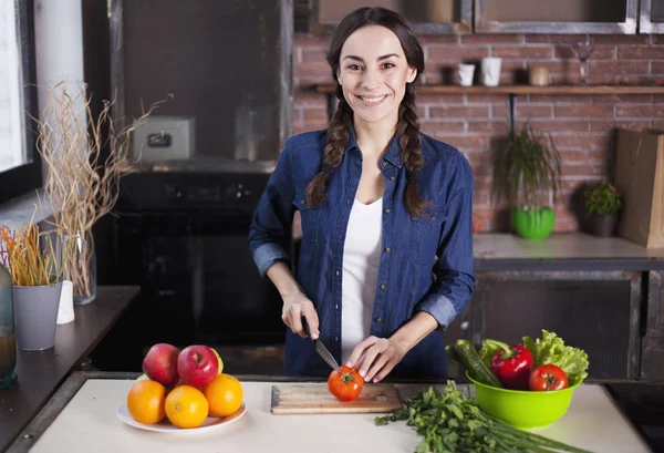 Jonge vrouw koken in de keuken thuis. Gezonde voeding. Dieet. Dieet Concept. Gezonde levensstijl. Thuis koken. Eten bereiden. Zeer mooie vrolijke jonge brunette vrouw die lacht. — Stockfoto