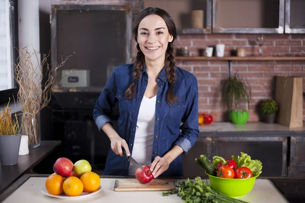 Young Woman Cooking in the kitchen at home. Healthy Food. Diet. Dieting Concept. Healthy Lifestyle. Cooking At Home. Prepare Food. Very Beautiful cheerful young brunette woman smiling.