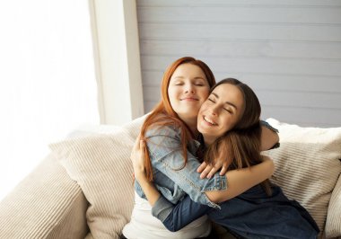 Oturma odasında kanepede sarılma arkadaşlar