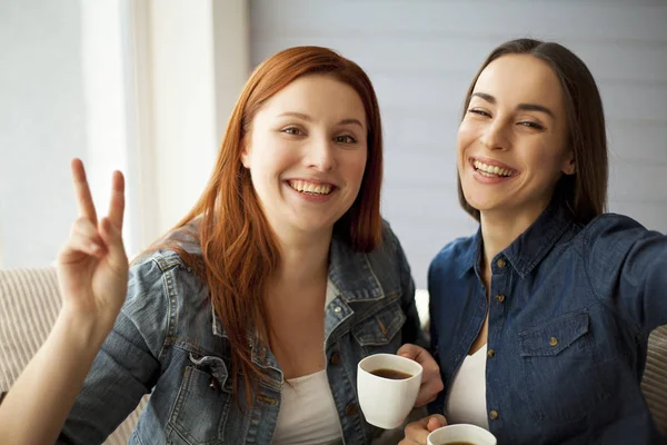 Vrolijke meisjes houdt kopjes koffie — Stockfoto