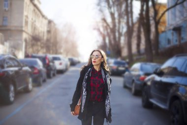 Genç bir kadın yolda yürüyor.