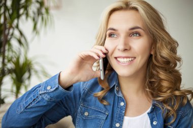 Kadın cep telefonuyla konuşuyor.