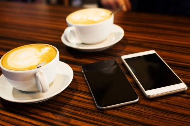 bardak kapuçino ve iki akıllı