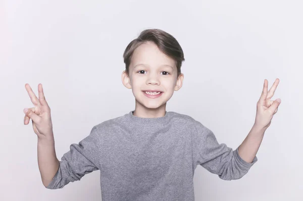 Pequeño niño mostrando gesto de victoria — Foto de Stock