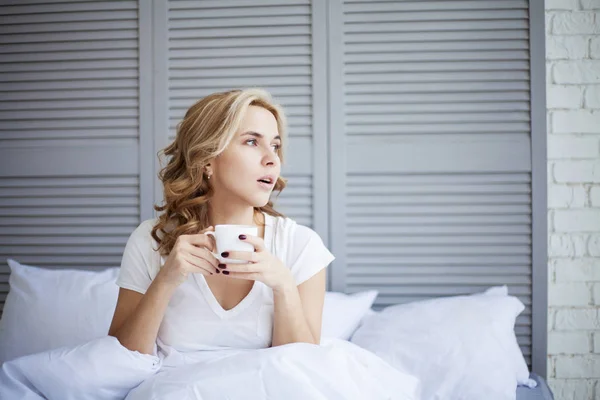 Жінка п'є каву в ліжку — стокове фото