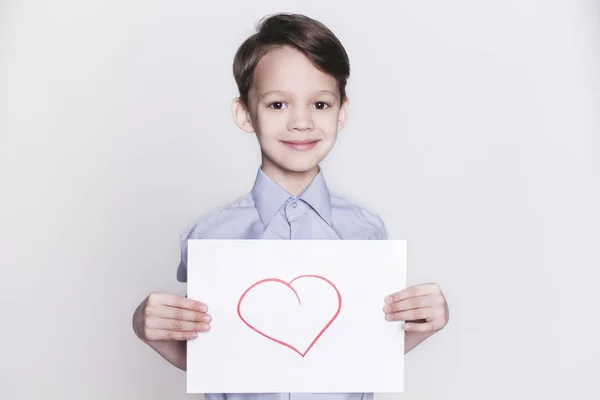Μικρό αγόρι κρατώντας χαρτί με το σύμβολο της καρδιάς — Φωτογραφία Αρχείου