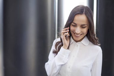 İş kadını cep telefonuyla konuşuyor