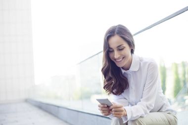 İş kadını akıllı telefon kullanıyor.